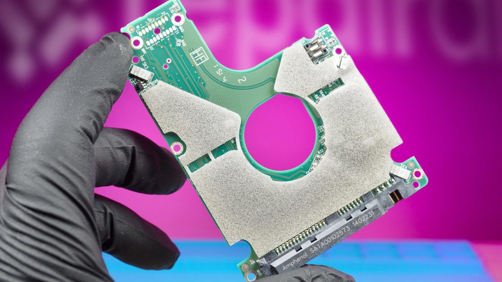 Gloved hand holding the pcb from a faulty hard drive at repair alliance dundee