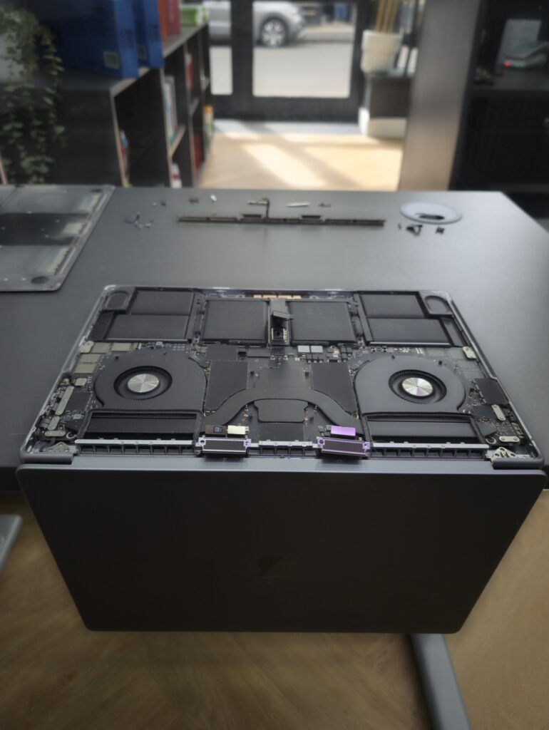 MacBook Pro 16 internals with antenna flex cables visible near the hinge after the display cable has been disconnected