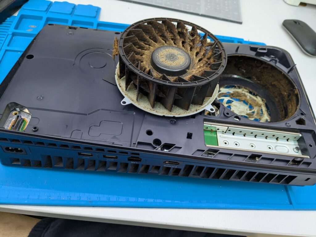 Closeup of the PlayStation 5 Slim cooling fan with thick dust packed between every blade after years of use
